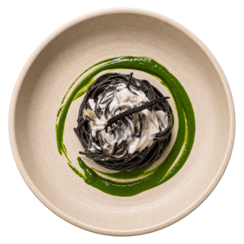 Nido di spaghetti al nero di seppia su salsa verde